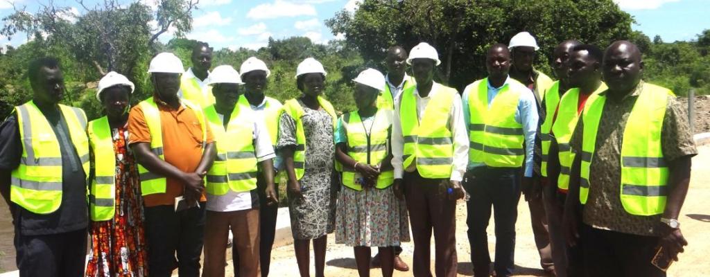 Road committee members pose for a photo moment during monitoring of roads in Amuru District
